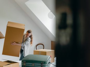 woman carrying boxes in new apartment