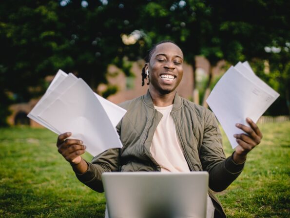 student with documents and laptop happy about getting into university