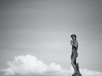 a statue of a man near the clouds